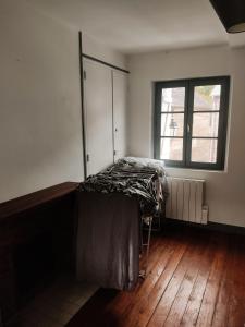 1 dormitorio con 1 cama con tocador y ventana en Maison en charpentes - 2 nuits minimum, en Lyons-la-Forêt