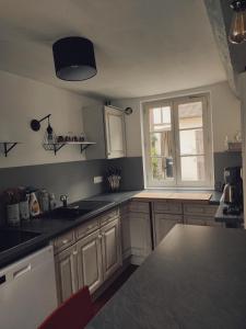 una cocina con fregadero y una ventana. en Maison en charpentes - 2 nuits minimum, en Lyons-la-Forêt
