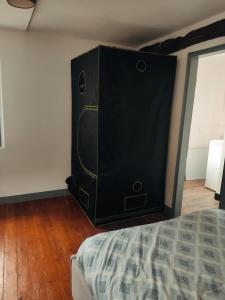 1 dormitorio con 1 cama y altavoz negro grande en Maison en charpentes - 2 nuits minimum, en Lyons-la-Forêt
