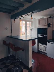 una cocina con encimera y taburetes. en Maison en charpentes - 2 nuits minimum, en Lyons-la-Forêt
