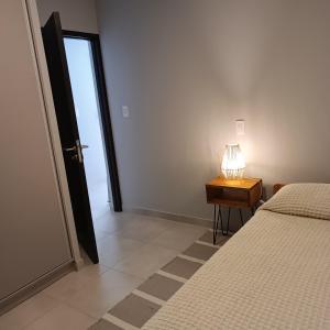 a bedroom with a bed and a table with a lamp at Serenity in Godoy Cruz