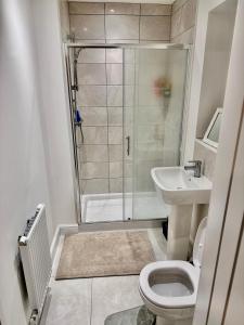 a bathroom with a shower and a toilet and a sink at Stylish Lux in Morley