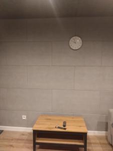 a room with a table and a clock on a wall at Bydgoszcz Kawalerka 2 in Bydgoszcz
