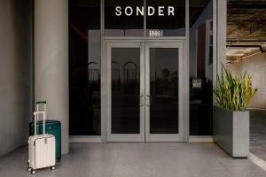 una valigia è seduta fuori da una porta di vetro di Sonder by Marriott Bonvoy 17WEST Apartments a Miami Beach Altre 32 foto