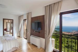 Luxury Villa Flower في بودفا: غرفة نوم بسرير ونافذة كبيرة