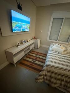 - une chambre avec un lit et une télévision murale dans l'établissement Locação Terras de São Francisco, Quarto Privativo Ipê Amarelo, à Andradas