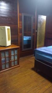 sypialnia z łóżkiem i telewizorem na stole w obiekcie Chalé urbano w mieście Miguel Pereira