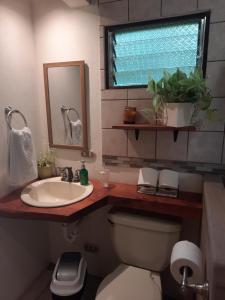 a bathroom with a sink and a toilet and a mirror at Casa Vista del Valle in Jesus