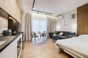 Una habitación de hotel con una cama y una sala de estar. en Kilińskiego Residence, en Łódź