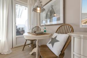 ein kleiner Tisch und Stühle in einem Zimmer mit Fenster in der Unterkunft Inselliebe, App.18 in Wenningstedt-Braderup