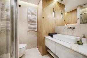 Un baño con un lavabo blanco y un inodoro. en Kilińskiego Residence, en Łódź 35 fotos más