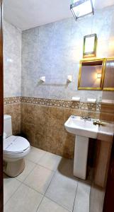 y baño con aseo, lavabo y espejo. en Hotel Plaza Baratillo en Guanajuato