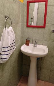 a bathroom with a sink and a mirror and a towel at Taffy's House in San Pedro de Atacama