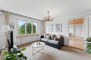ein Wohnzimmer mit einem Sofa und einem Tisch in der Unterkunft Lakeview apartment in beautiful Oberhofen in Oberhofen am Thunersee