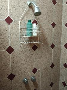 a shower with a shower head with two water bottles at Pequeño y acojedor departamento muy bien ubicado in Veracruz