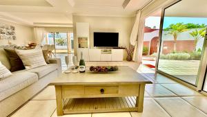 een woonkamer met een bank en een tafel bij Beautiful Villa Amorio - Private Heated Pool with Sea Views & WIFI in Adeje