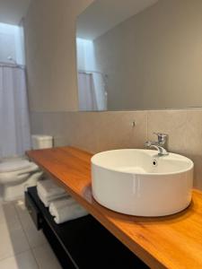 a bathroom with a white sink on a wooden counter at Complejo Carrodilla - Lujan de Cuyo in Ciudad Lujan de Cuyo