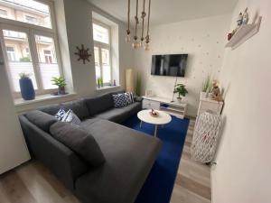 a living room with a couch and a table at N A U T I C A - ruhige maritime Ferienwohnung mit Balkon familienfreundlich in Rostock