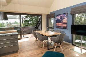 een keuken en eetkamer met een houten tafel en stoelen bij Heaven House Penthousewohnung Siebter Himmel in Timmendorfer Strand