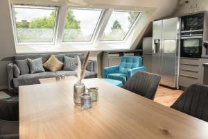een keuken en woonkamer met een tafel en stoelen bij Heaven House Penthousewohnung Siebter Himmel in Timmendorfer Strand