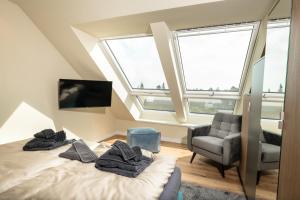 een slaapkamer met een bed, een stoel en ramen bij Heaven House Penthousewohnung Siebter Himmel in Timmendorfer Strand