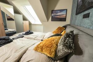 een slaapkamer met een groot bed met kussens erop bij Heaven House Penthousewohnung Siebter Himmel in Timmendorfer Strand +29 foto's