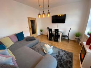 un soggiorno con un divano e un tavolo di ZUR SCHLEUSE - Ferienwohnung bis 6 Personen mit gem Garten a Rostock
