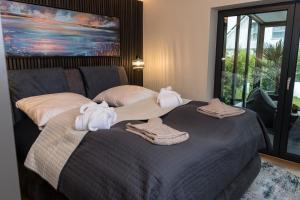 1 dormitorio con 1 cama grande y toallas. en Wellness House Oase Spa mit Whirlpool en Timmendorfer Strand