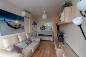 a living room with a couch and a table at Cosy 2BR flat in Nuevo Portil city centre in El Portil