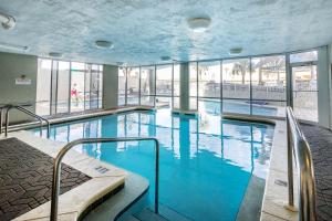 a swimming pool with blue water in a building at SeaCrest 413 condo in Fort Walton Beach