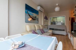 Cosy 2BR flat in Nuevo Portil city centre في إل بورتيل: غرفة معيشة مع أريكة وطاولة