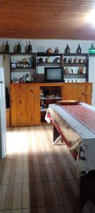 a kitchen with a table in the middle of a room at Sítio do Dindinho - Aiurê in Grão Pará +9 photos