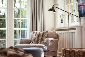 a living room with a chair and a lamp at Familier Hygge Hus in Braderup