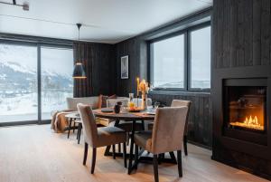 a dining room with a table and a fireplace at Helt ny leilighet i Hemsedal, rett ved Fyri Resort - Ski inn - Ski out in Hemsedal
