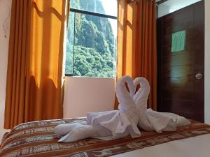 una pila de toallas sentadas encima de una cama en CUSI QOYLLOR en Machu Picchu