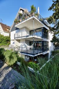 een wit huis met een balkon en een terras bij Cosmopolitan in Überlingen