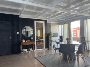 a living room with a table and chairs and a mirror at Apto duplex Lagoa do Violão in Torres