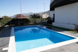 a large blue swimming pool next to a house at Villa Nebros in SantʼAgata di Militello