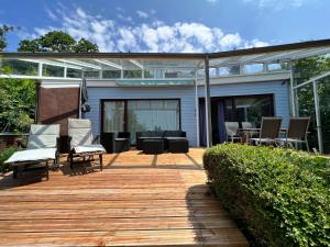 una terraza con sillas y mesas en una casa en Ferienhaus Wellnesshütte mit Außenwhirlpool und herrlichem See-und Alpenblick en Überlingen