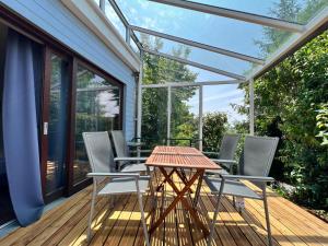 un patio con mesa y sillas en una terraza en Ferienhaus Wellnesshütte mit Außenwhirlpool und herrlichem See-und Alpenblick, en Überlingen