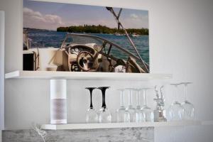 a shelf with wine glasses and a picture of a boat at Maisonette Alpenblick in Überlingen