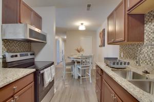 a kitchen with wooden cabinets and a table with a dining room at Greensboro Vacation Rental Condo Near Downtown in Greensboro