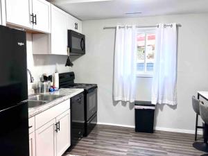 uma cozinha com um lavatório, um fogão e uma janela em Nallo Stays Home Away From Home! em Sioux Falls