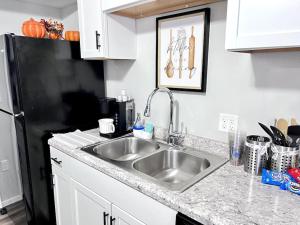 a kitchen with a sink and a black refrigerator at Nallo Stays Home Away From Home! in Sioux Falls