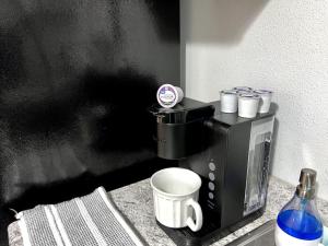 Nallo Stays Home Away From Home! في شلالات سيوكس: آلة صنع القهوة السوداء على منضدة مع كوب