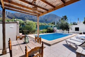 a villa with a swimming pool and a wooden pergola at Villa Anna in Jávea