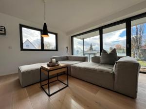 a living room with a couch and a table at seenahe Design-Ferienwohnung Loft Azur in Überlingen