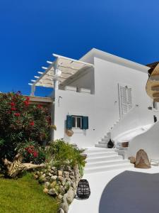 una casa bianca con scale bianche e fiori di Casa Vacanze Le Palette - Glicine a Ponza