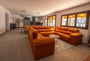a living room with a brown couch and a kitchen at Casa Rural El Cuartel de Uclés in Uclés +64 photos