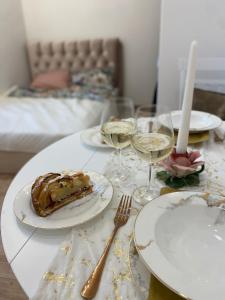 einen Tisch mit Teller mit Speisen und Gläsern Wein in der Unterkunft Golden Rush in Riga